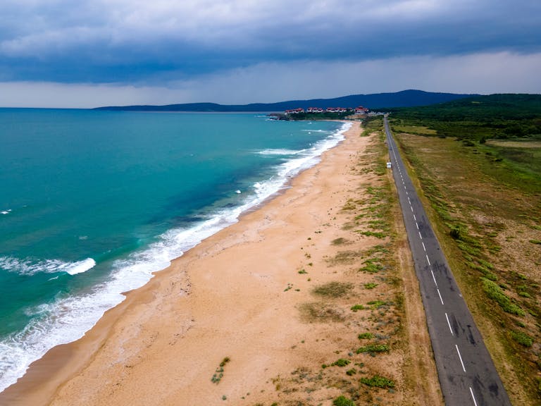 Aerial shot of Dyuni beach and coastline with a road alongside the scenic landscape.