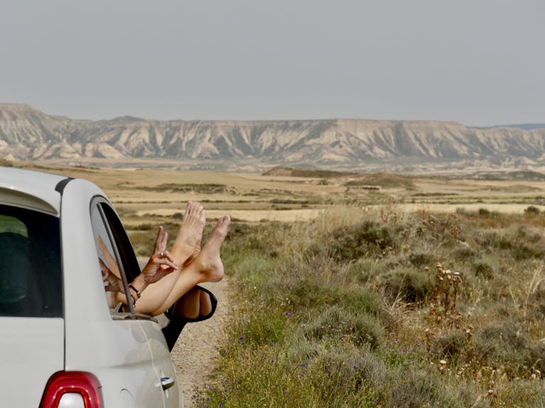 Enjoying a road trip with feet out the window in the Bardenas Reales desert, Spain.